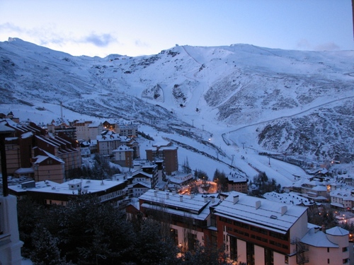 Byn och backarna i Sierra Nevada bakifrån i skymningen